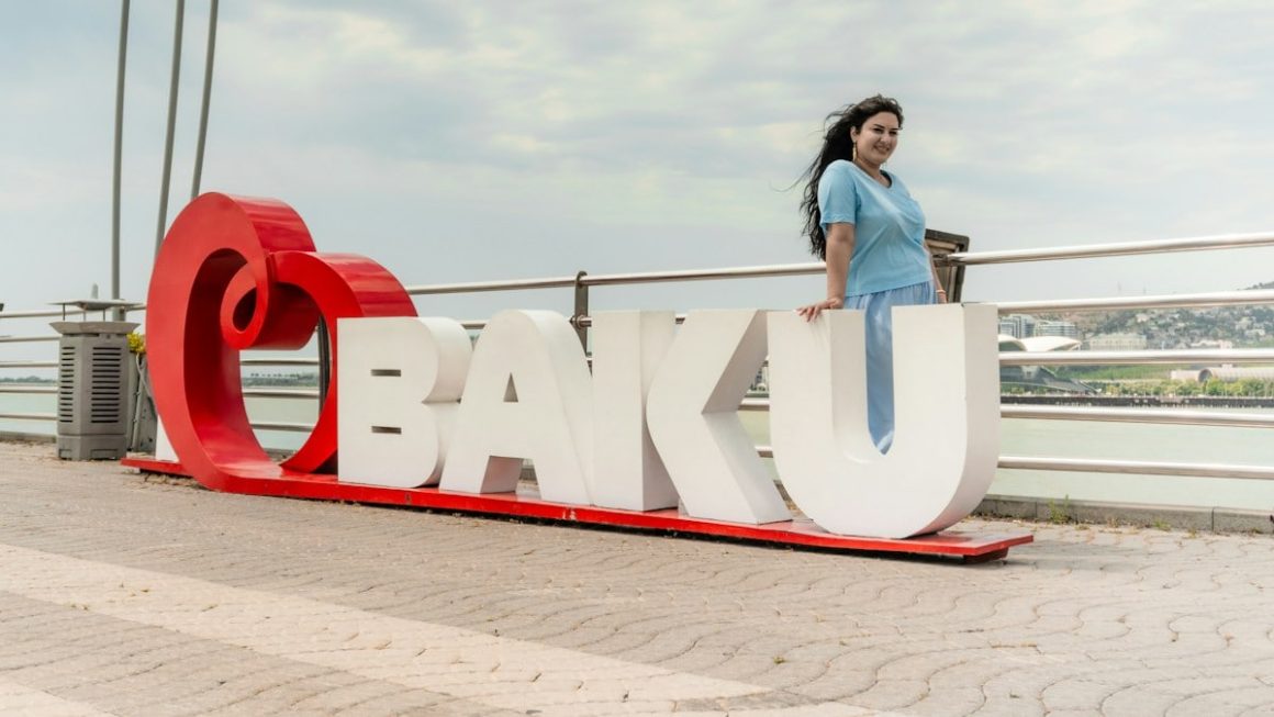 Woman standing by a large red and white "baku" sign